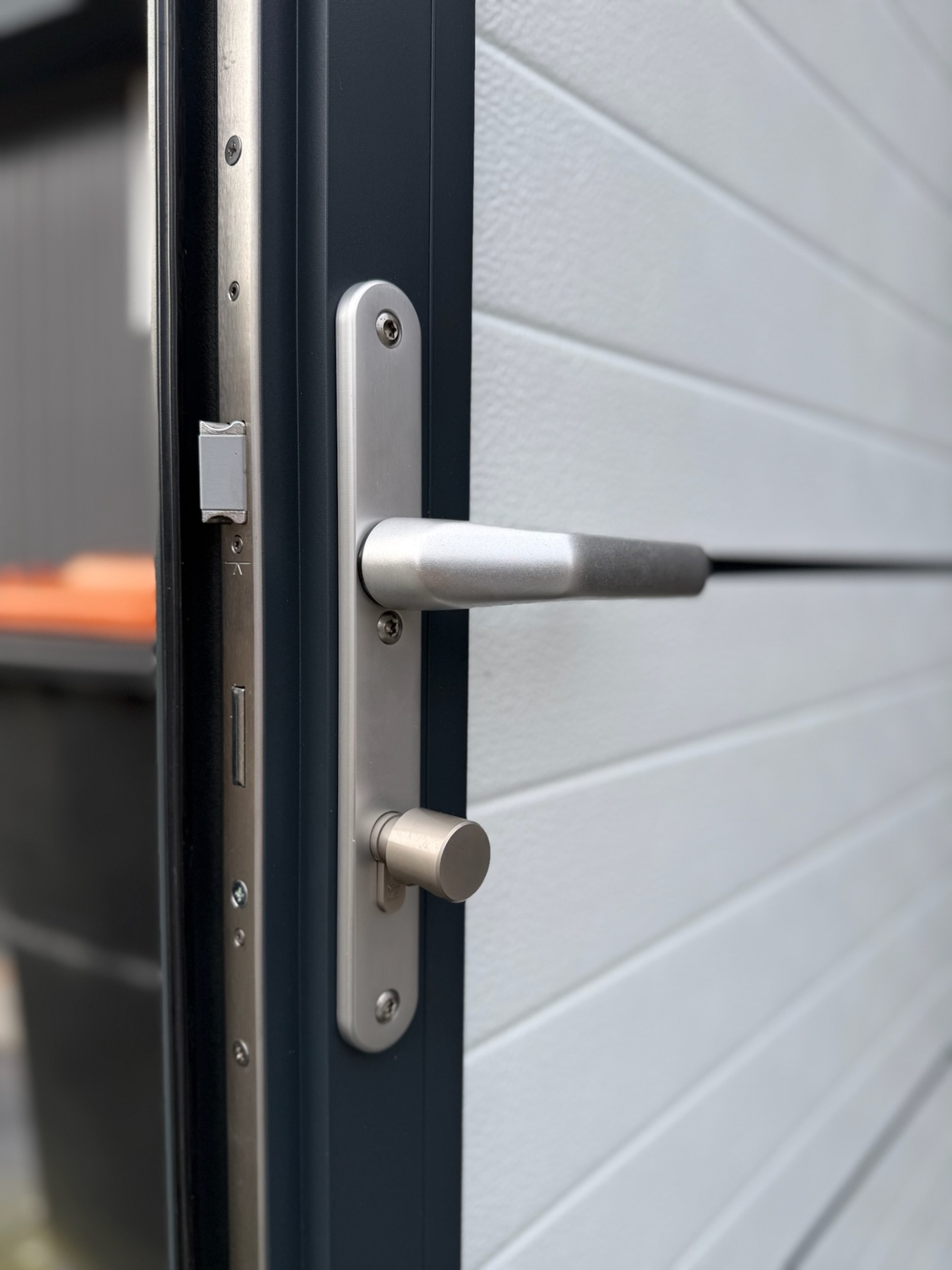 Close-up rvs deurkruk en cilinderslot garagedeur
