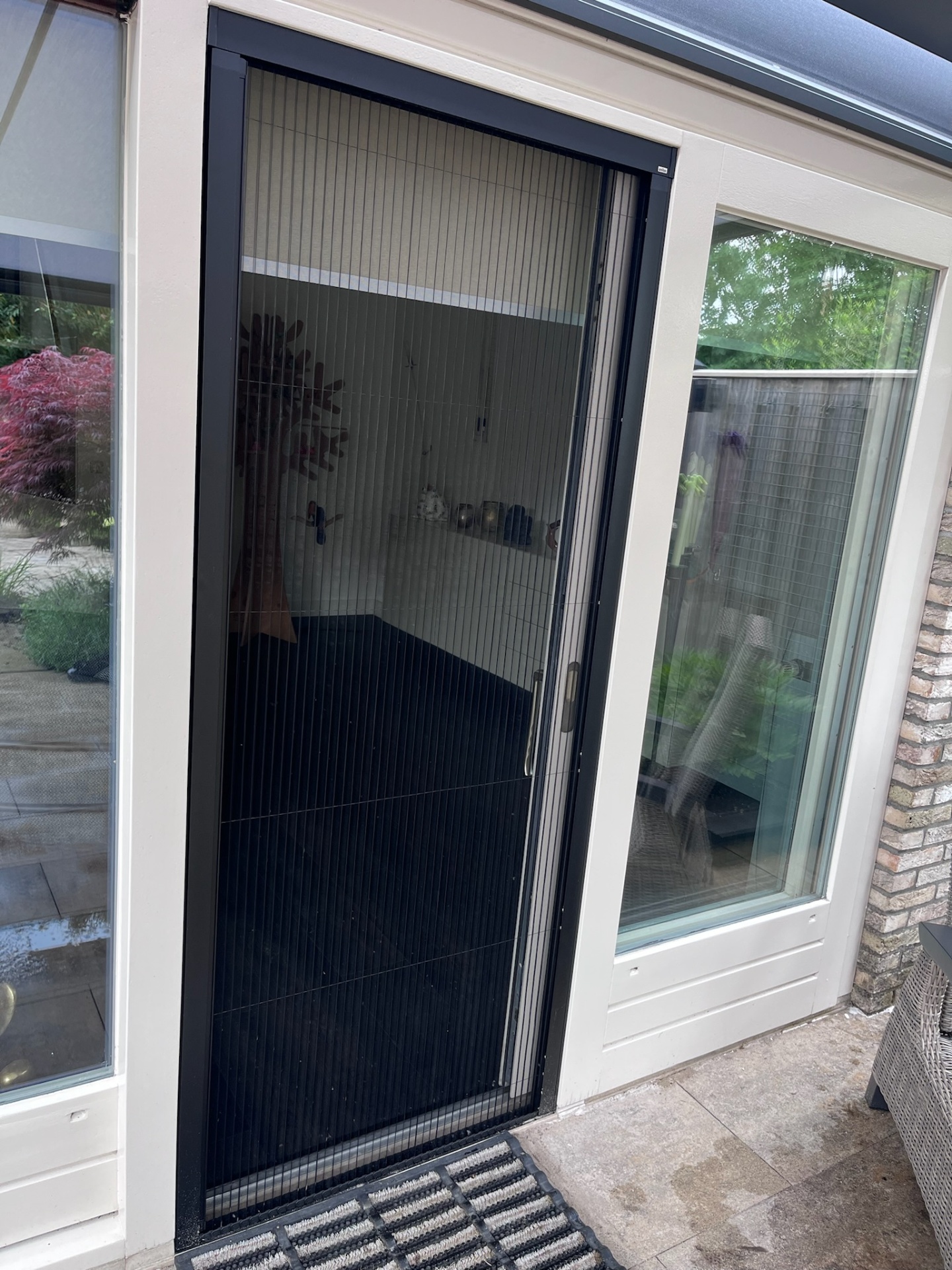Plissé hordeur met zwart aluminium frame in serre