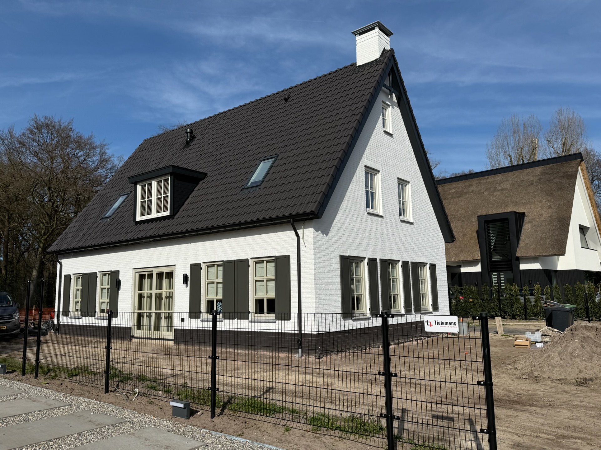 Villa met open groene luiken en wit pleisterwerk