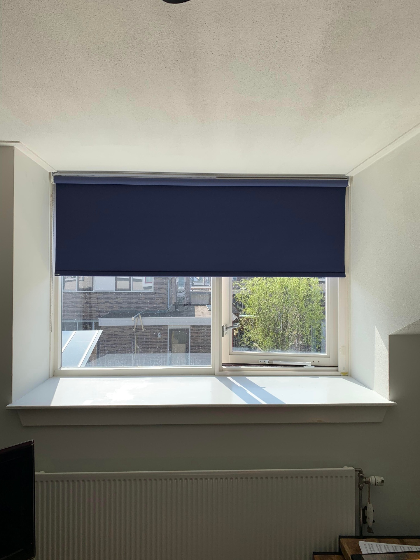 Verduisterend rolgordijn in donkerblauw doek in slaapkamer