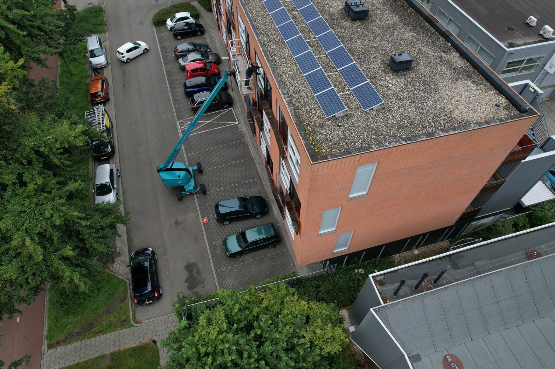 Vakmontage van screens op kantoorpand met hoogwerker