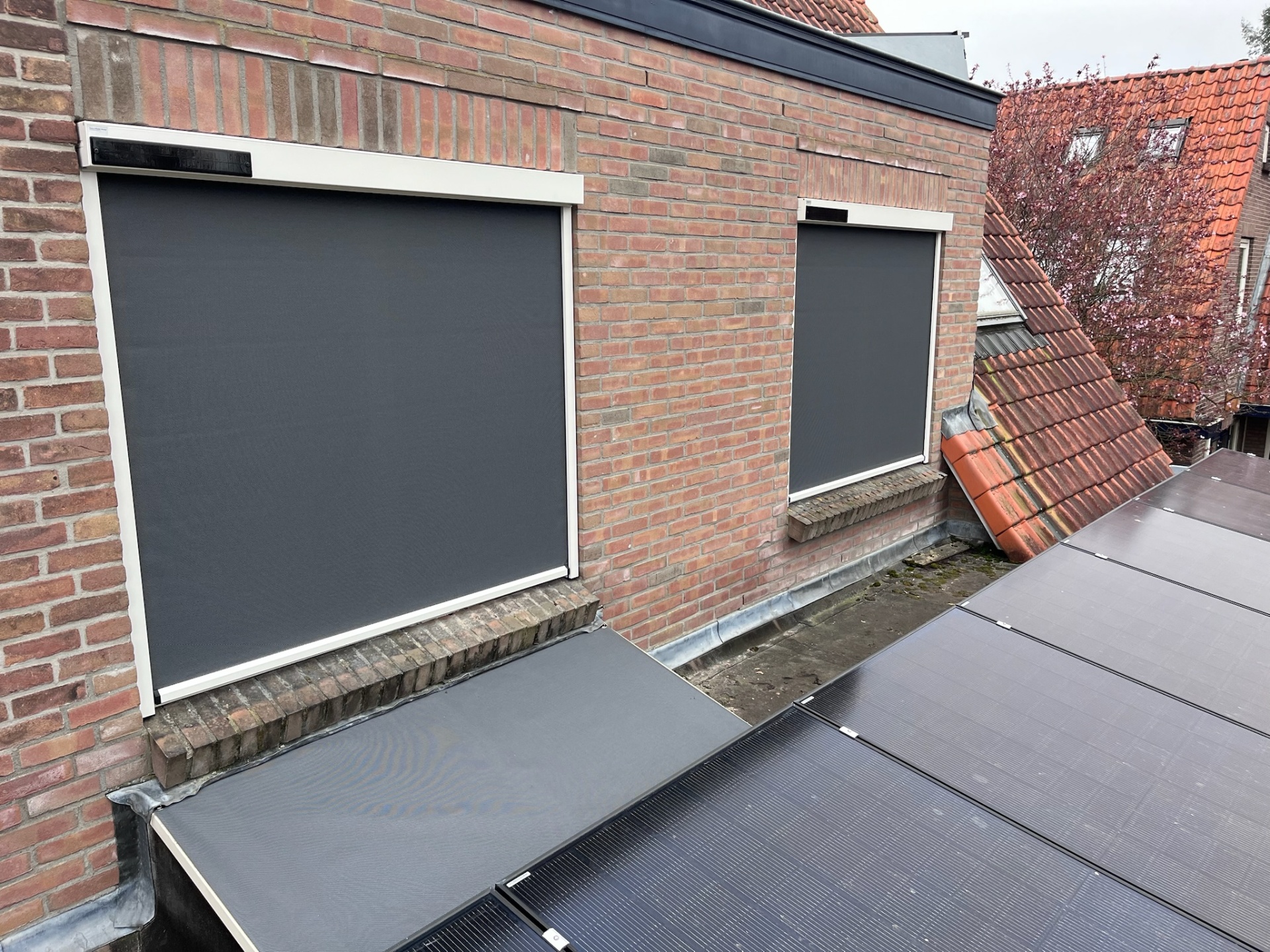 Twee zip-screens met zonnecel op dakkapel naast zonnepanelen